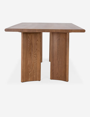 Side view of the Sun at six crest sienna wood dining table with curved legs