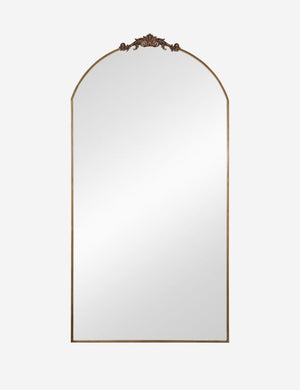 Tulca gold curved standing mirror with flat bottom edge and traditional scroll detailing.