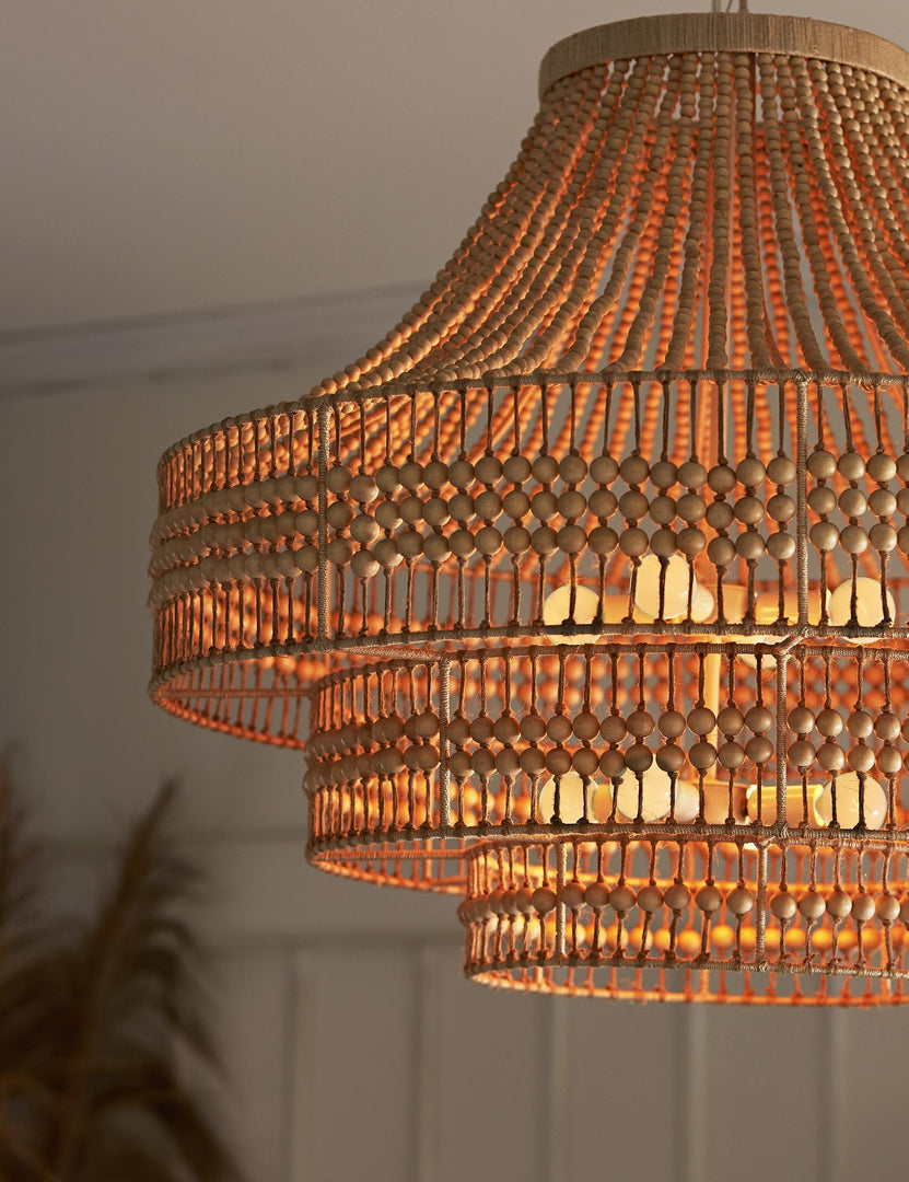 | The Tulane open-woven wooden chandelier by Arteriors in a dark room with its lights on