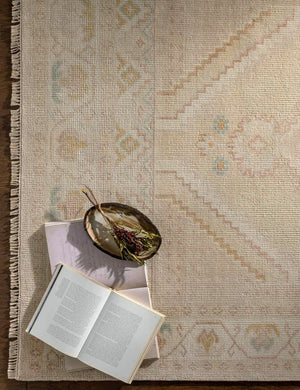 The corner of the lotus rug with fringe with a book and bowl atop it