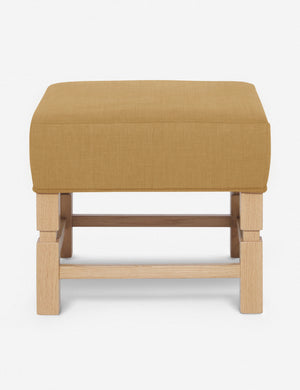 Ambleside Camel yellow linen upholstered ottoman by Ginny Macdonald with a carved frame and vertical channeling on the cushion