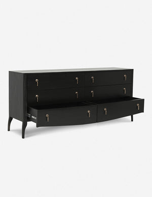 Angled view of the Anabella black wood dresser with silver drawer pulls with its bottommost drawer open