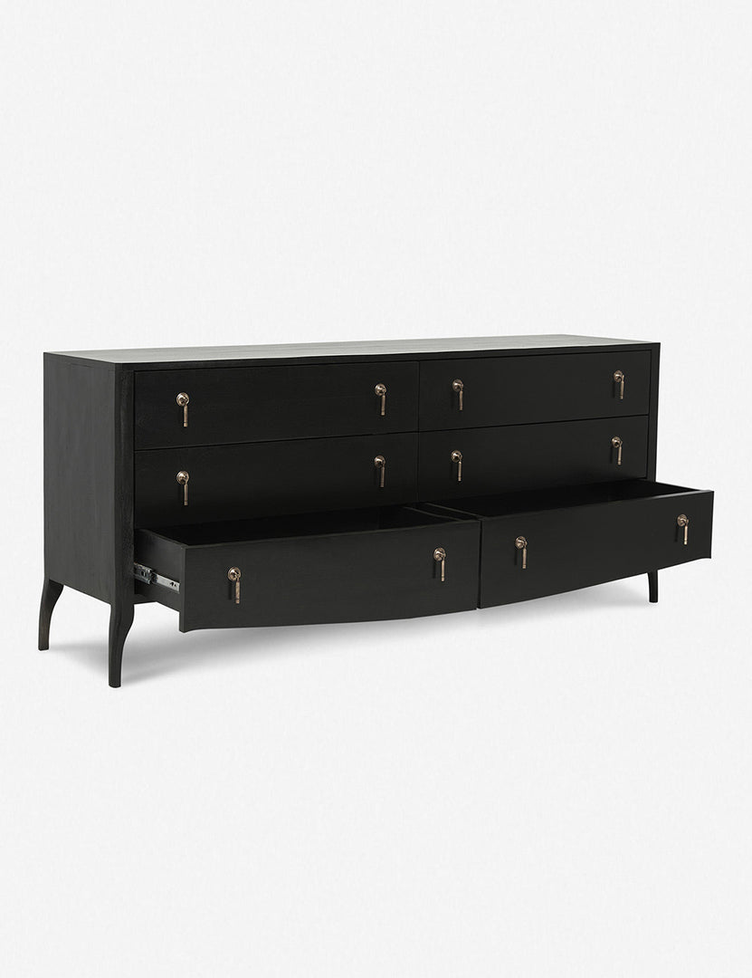 | Angled view of the Anabella black wood dresser with silver drawer pulls with its bottommost drawer open