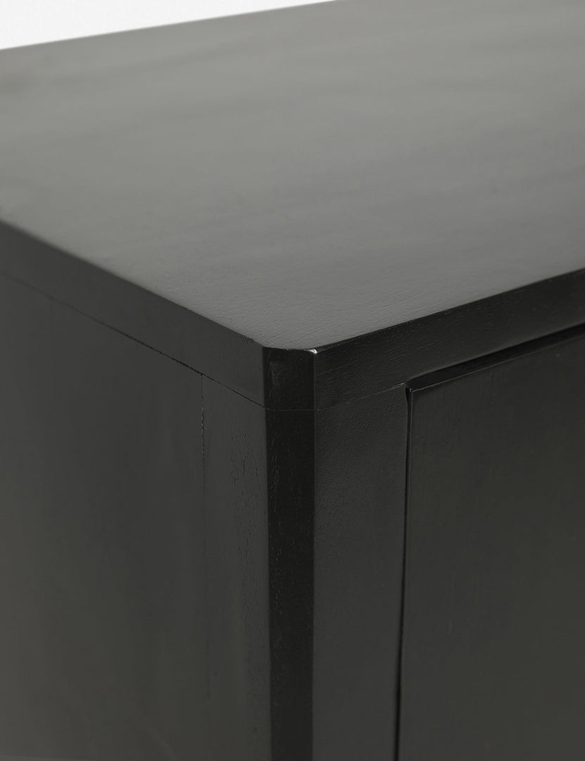 | Close-up of the joint work on the upper left corner of the Anabella black wood console table with silver drawer pulls