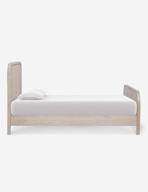 Side view of the Brooke whitewashed platform bed with cane paneling