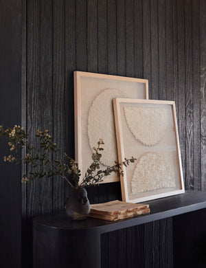 Sonnet I & II Wall Art sit above a black oval console table against a black wooden wall next to a sculptural vase