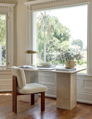 Sydney Dining Chair sits next to a marble desk in a room with large accented windows and a polished brass desk lamp