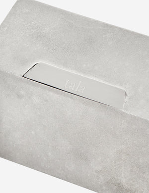 Close-up of the tala logo on the sand casted stainless steel hardware on the Basalt slender hexagonal 9-light pendant light by tala