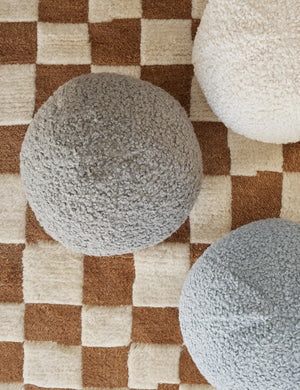 Bird’s-eye view of the Khaki gray Bouclé Ball Pillow by Sarah Sherman Samuel on a ochre and white patterned rug