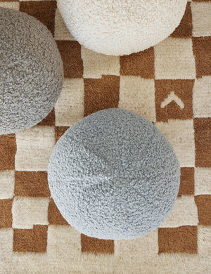 Bird’s-eye view of the Canyon blue Bouclé Ball Pillow by Sarah Sherman Samuel on a ochre and white patterned rug