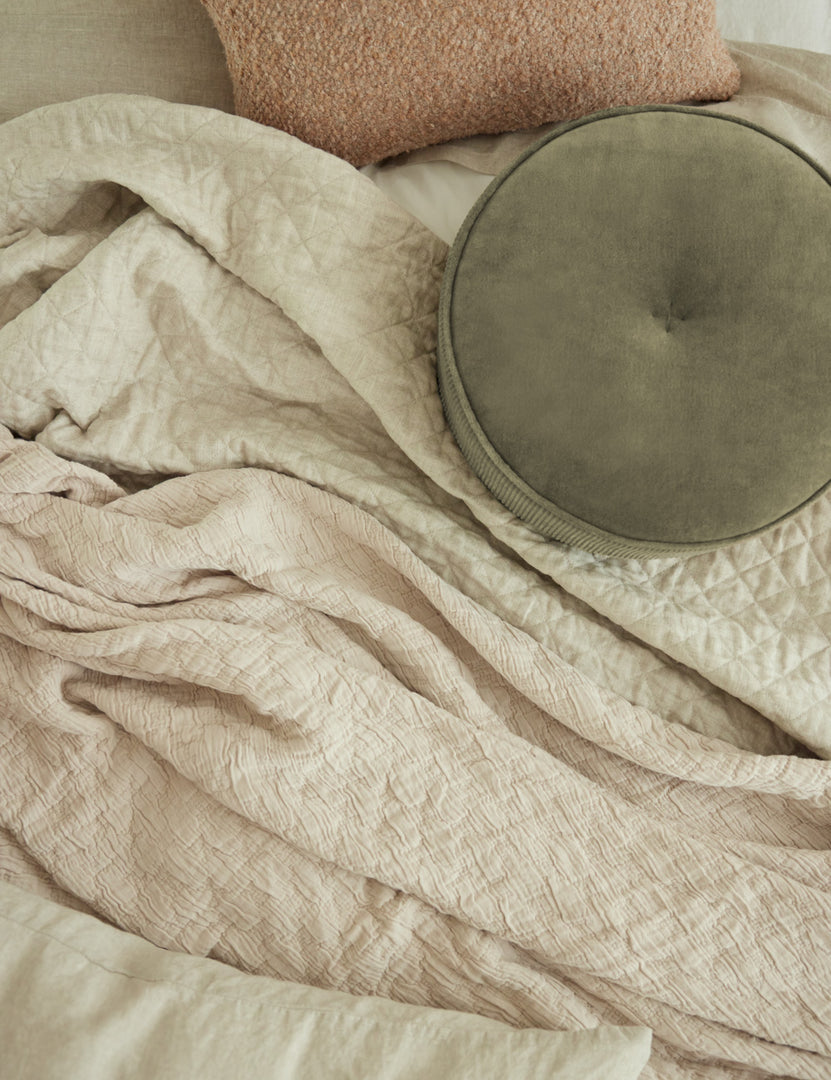 #color::flax #size::king #size::queen #size::twin | The Hampton flax Quilted Coverlet by Pom Pom at Home lays with a pink boucle throw pillow and an olive-toned velvet disc pillow