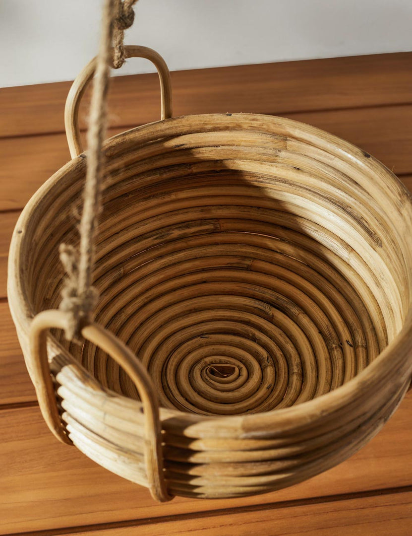 | View of the spiral pattern on the inside of the Brandie Hanging Woven Rattan Basket with jute straps