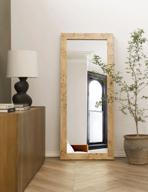 Bree Burl Wood Rectangular Floor Mirror sits on the corner of a room with a sculptural lamp