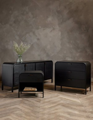 The Brooke black solid oak sideboard sits in a studio with the brooke nightstand and three drawer dresser