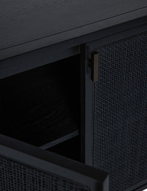 Close-up of the iron pull and an open rattan door on the Brooke black solid oak sideboard