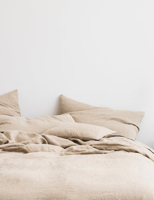 The European Flax Linen natural Duvet Cover by Cultiver lays on a bed with other cultiver linens