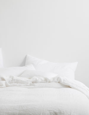 The European Flax Linen white Duvet Cover by Cultiver lays on a bed with other cultiver linens