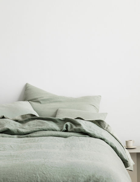 #color::sage #size::queen #size::king | The European Flax Linen sage green Duvet Cover by Cultiver lays on a bed with other cultiver linens