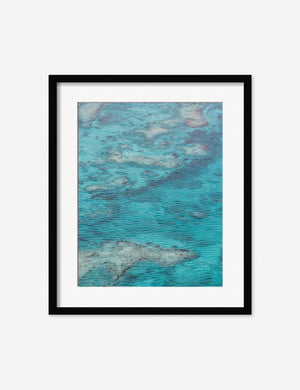 Turks & Caicos Photography Print in a black frame features saturated sea-blue hues ripple over barely submerged geological features