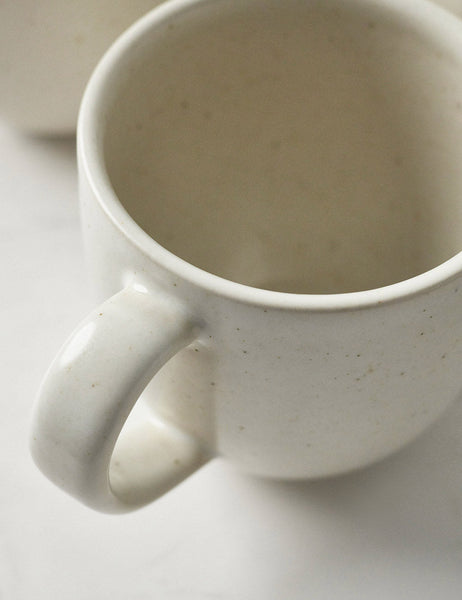 #color::vanilla | Close-up of the mug in the Pacifica Vanilla-toned Dinnerware 5-Piece Place Setting by Casafina