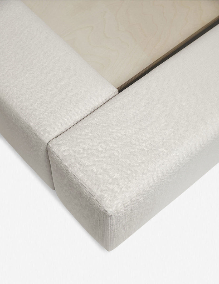 #size::queen #size::king #size::cal-king #color::ivory | Close-up of the corner at the end of the Clayton ivory upholstered platform bed