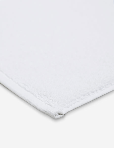 #color::white | Corner shot of the Cloud loom sustainable white bath mat by coyuchi