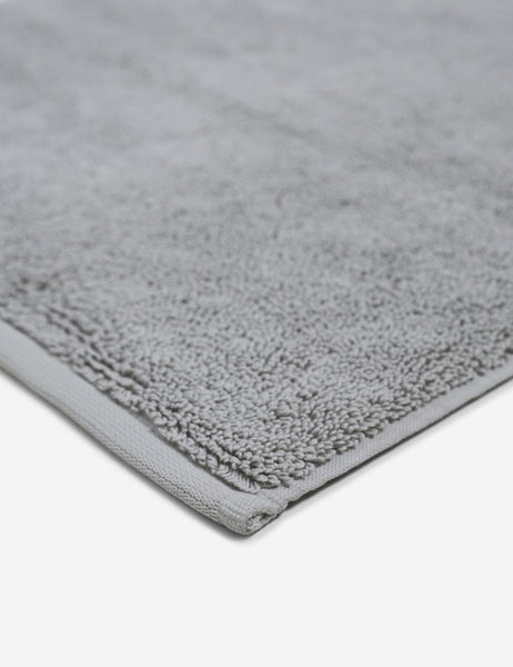 #color::fog | Corner shot of the Cloud loom sustainable light gray bath mat by coyuchi