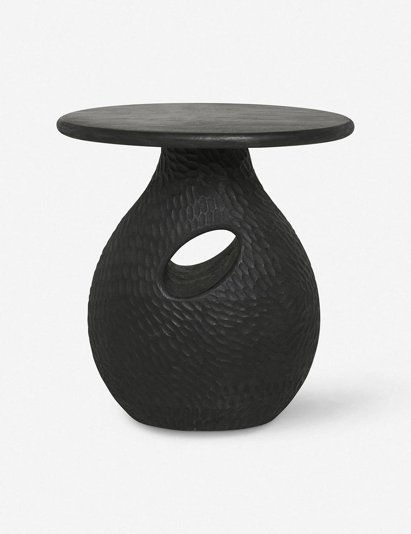 | Corso black mango wood side table with a pear-shaped based, circular top, and carved window