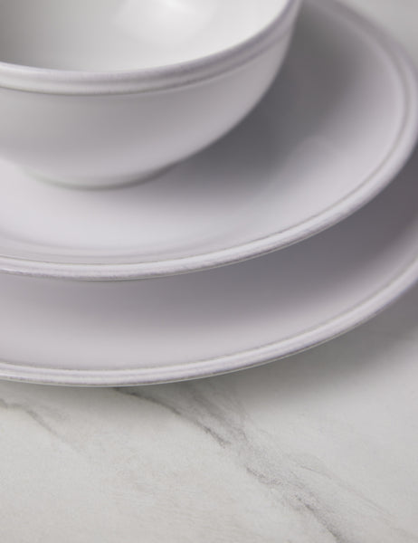 #color::white | Close-up of the grooved edge on the Friso white dinnerware 5-piece place setting by Costa Nova