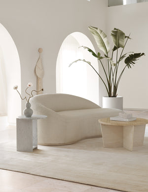 The ivory dylan rug lays in a room with high ceilings and arched entryways under a boucle media lounger