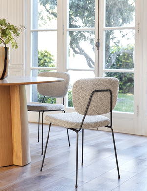 Two of the Hayes Dining Chairs sit around a natural wooden dining table in a dining room with white walls and french doors