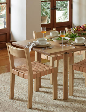 Vix light wood frame and woven leather seat dining chair styled with a light wood dining table and natural ivory rug.