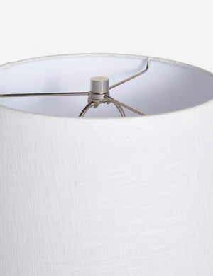 The silver hardware and the white linen shade on the top of the Duffy white table lamp