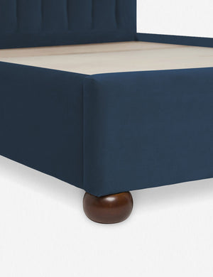Close up of the corner and round wooden legs of the Blue Evelyn Platform Bed