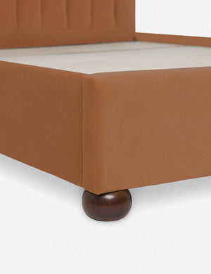 Close up of the corner and round wooden legs of the Rust Orange Evelyn Platform Bed