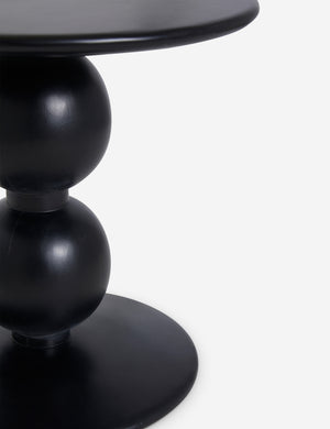 Close up view of the Genesis round black sculptural side table.