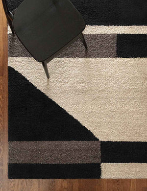 Bird's-eye view of the Hidara rug laying under a black wooden dining chair