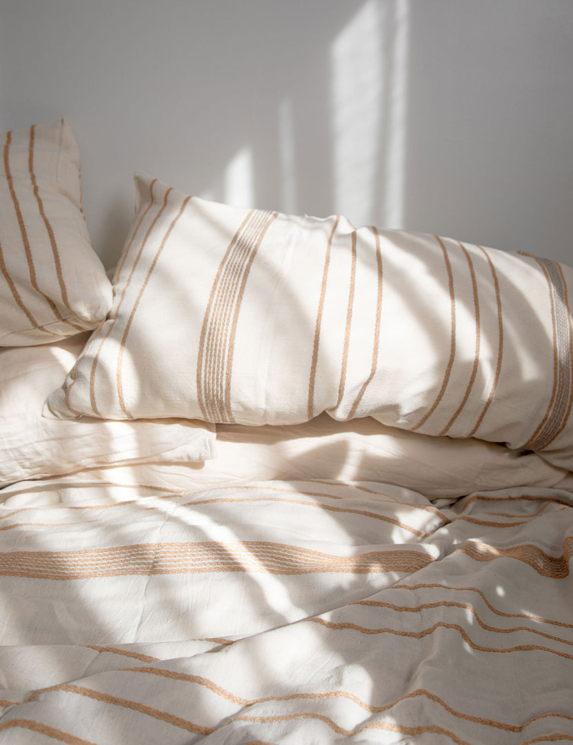 #color::beige #size::queen #size::king | The Marlo Cotton hand loomed beige striped Duvet Set by House No. 23 lays on a bed in a sunny bedroom