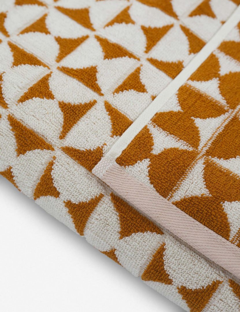 #color::sudan-brown-moon | Close-up of the Harper orange and white towel by house number 23 with half-moon designs