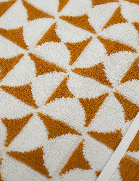 #color::sudan-brown-moon | Close-up of the Harper orange and white towel by house number 23 with white half-moon designs