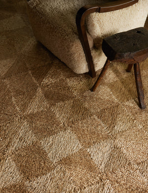 Close up of the Havenhurst Rug laying under a small round wooden stool and sherpa accent chair