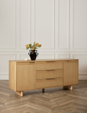 The Hillard white oak veneer five drawer sideboard sits in a studio with a white ruffle bowl and black glossy vase atop it