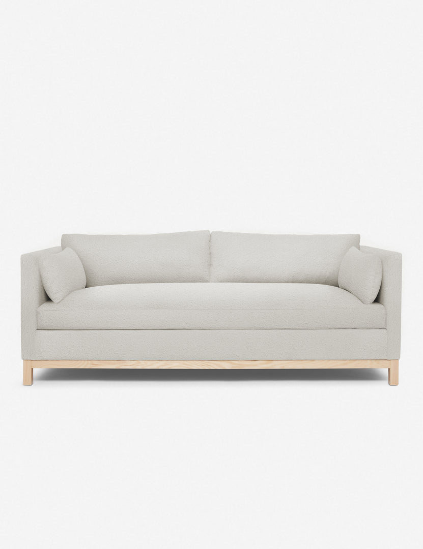Back view of rust-orange sofa highlighting its soft fabric and exposed wood frame.