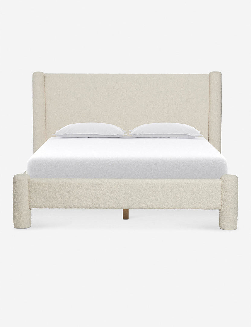 Warm tan upholstered bed with rounded posts and white bedding, mid-century style.