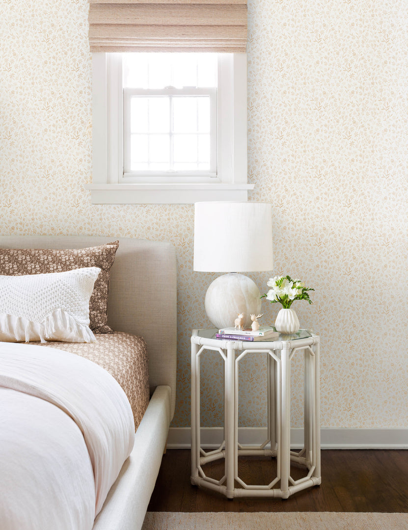 #color::goldenrod | The sommerville goldenrod wallpaper is in a bedroom with natural framed bed next to a hexagonal white nightstand