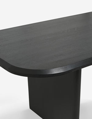 The top and flat slab-style leg of the Archer Black Rectangular Dining Table