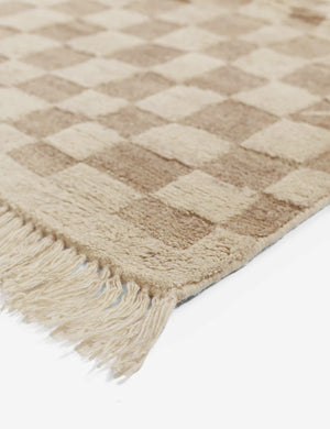 Close-up of the corner and tassels on the Irregular beige checkerboard rug by Sarah Sherman Samuel