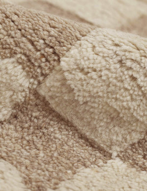 Detailed view of the high-low pile fiber and texture on the Irregular beige checkerboard rug by Sarah Sherman Samuel