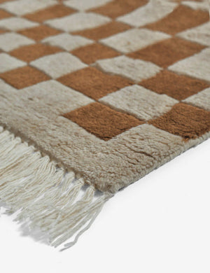Close-up of the corner and tassels on the Irregular brown checkerboard rug by Sarah Sherman Samuel