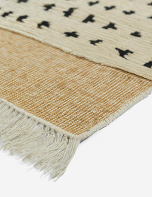 The flatwoven border and fringe on the corner of the irregular dots rug